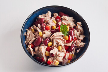 Poster - Closeup shot of a salad with red beans, corn, lettuce, and tiny-sliced meat in a black bowl