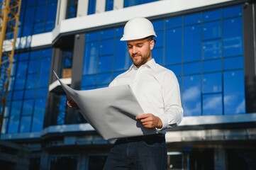 Architect in helmet near new building