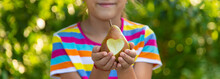 The Child Eats A Pear In The Garden. Selective Focus.