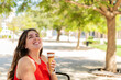 © Marcela Ruty Romero - Happy woman eating Ice cream cone at park, in sunny day.