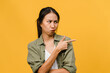 © tirachard - Young Asia Lady show something amazing at blank space with negative expression, excited screaming, crying emotional angry in casual clothing isolated over yellow background. Facial expression concept.