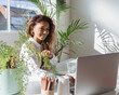 © Austockphoto - Young executive working in an office with indoor plants