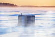 Ice Fishing hut on a frozen harbour in the mist.