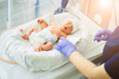 © Iryna - Unrecognizable nurse in blue gloves takes action and care for premature baby, selective focus on baby eye Newborn is placed in the incubator. Neonatal intensive care unit
