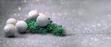 Fototapeta  - brokatowe bombki z iglastą gałązką na srebrnym brokatowym tle, świąteczne tło