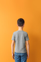 Canvas Print - Little boy in stylish t-shirt on color background, back view