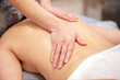 © alexlukin - Hands of the masseur on back of young woman