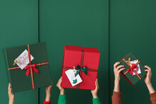 Women With Christmas Gift Boxes Near Green Wall