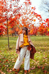 Wall Mural - Full body portrait of beautiful woman wearing stylish clothes in autumn park. Female fall fashion