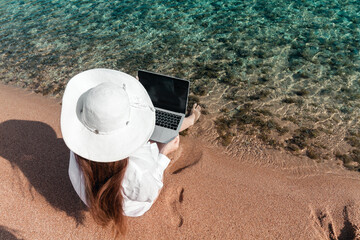 freelancer with a laptop works on a beach