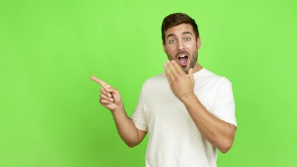 Wall Mural - Handsome man pointing to the side and presenting a product while smiling over isolated background