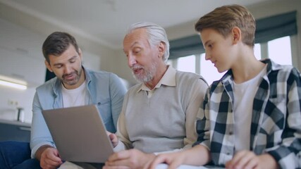 Wall Mural - Three family generations spending time together, discussing photo in laptop