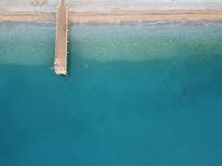 Sticker - Aerial view of a blue calm beach with soft sand and a wooden pier