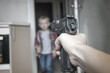 © Александра Замулина - Child abuse, dysfunctional family, parenting problems, firearms. Gun in women's hands. Woman aims at a child. Selective focus