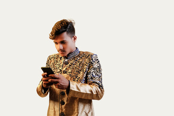 Canvas Print - Indian man in ethnic wear showing mobile screen, An isolated background