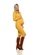 Young happy pregnant woman posing in a long yellow dress