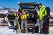 © phpetrunina14 - man and woman dressing into ski equipment near suv car