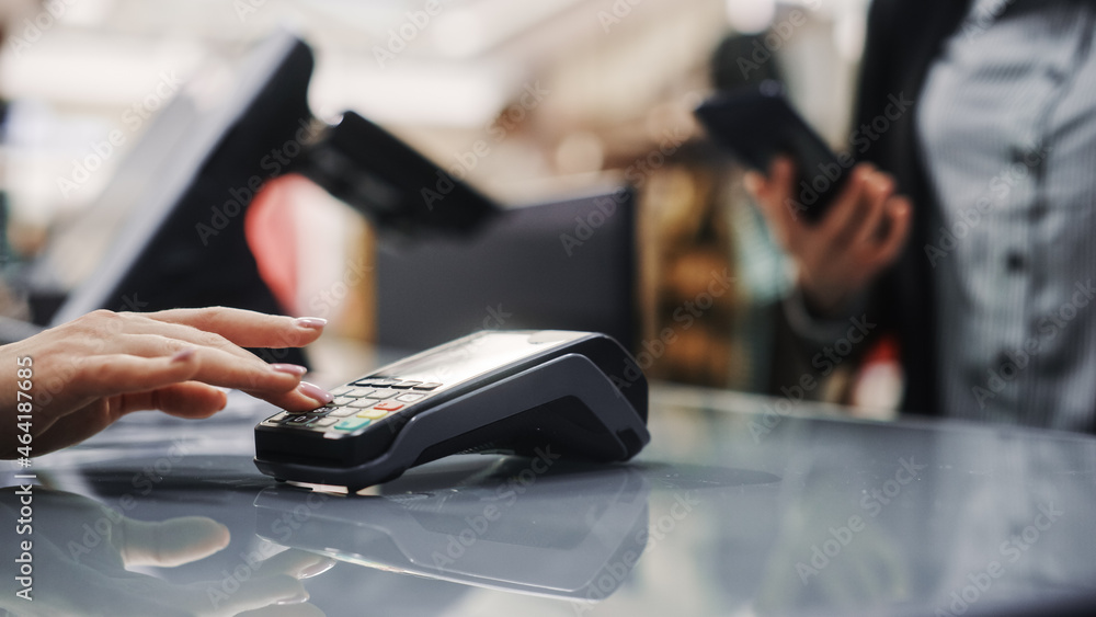 Foto Clothing Store: Woman At Counter Buys Clothes Paying with ...