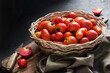 © tynza - Fresh red tomatoes in whicker basket on black background