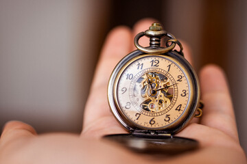 A man holding vintage pocket watch. Time concept.