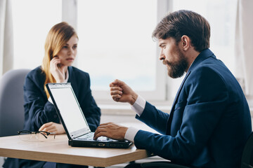 Poster - business man and woman in the office in front of a laptop career network officials