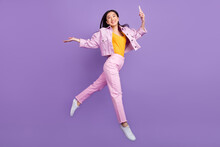 Full Size Profile Photo Of Funky Young Brunette Lady Jump Hold Telephone Wear Jacket Jeans Sneakers Isolated On Violet Background