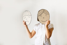 child with masks of emotions, joy and sadness. Psychology and children's emotions concept