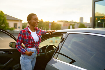 Wall Mural - Woman poses at clean car, hand auto wash station