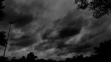 Wall Mural - a scenic shot of moody, rainy, and stormy clouds in the forest in black and white colors