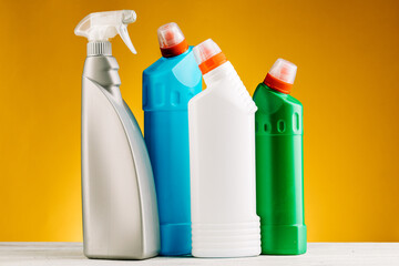 Bottles of detergent and cleaning products on a yellow background.