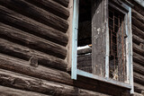 Fototapeta  - The wall of a burnt log house with a broken window, close-up.