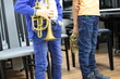 Two children young musicians with a musical trumpet standing in the classroom at the lesson listening to a lecture musical instrument in hand frontal view close-up