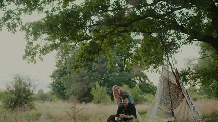 Canvas Print - Young Polish girl and guy enjoying a romantic atmosphere with a cute tent in the field