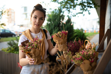 Wall Mural - attractive young woman in casual look buys flowers in the store