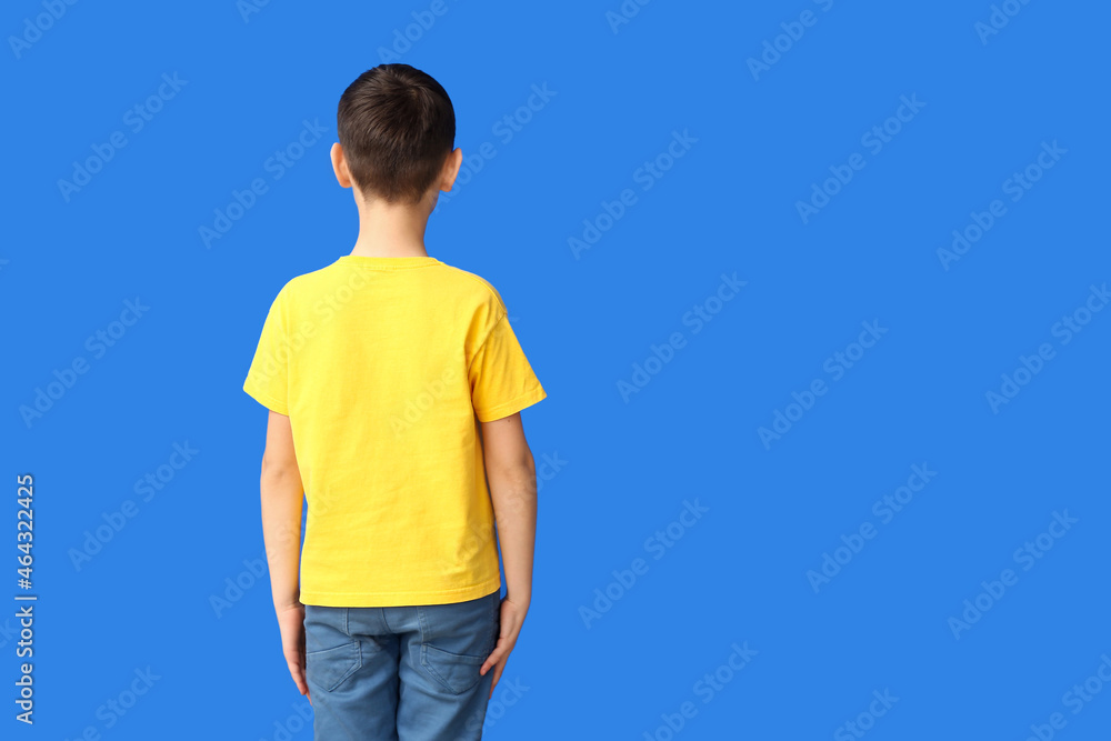 Little boy in stylish t-shirt on color background, back view