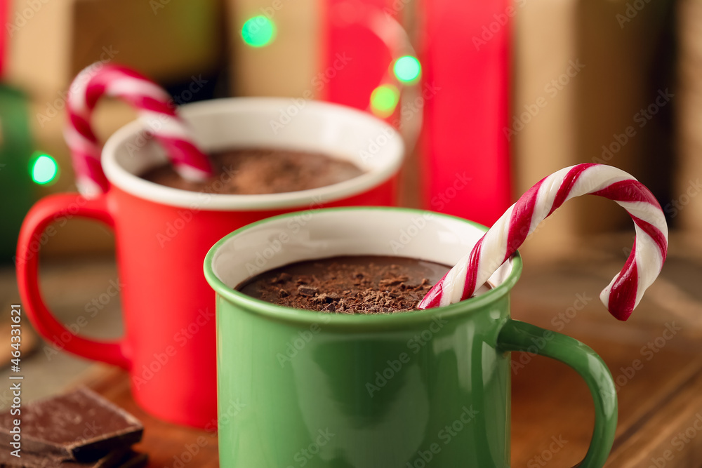 Mugs of delicious hot chocolate on table, closeup