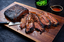 Modern Style Traditional Smoked Barbecue Wagyu Beef Brisket With Baby Broccoli Served As Top View On A Wooden Design Cutting Board With Louisiana Sauce