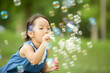 © amanaimages - 公園でシャボン玉で遊ぶ少女