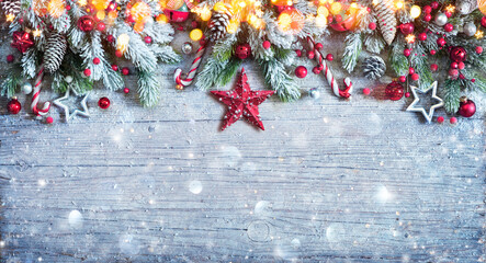 christmas ornament with fir branches and snow on blue wooden plank