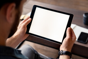 Man holding digital tablet device white screen in hand view over shoulder