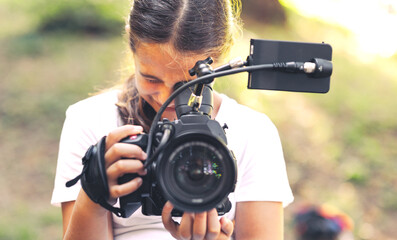 Cute girl shooting a video with a professional video camera