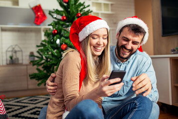 Wall Mural - Couple using phone at Christmas time