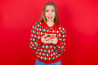 Photo of astonished crazy Young beautiful caucasian girl wearing christmas sweaters on red background hold smartphone dislike feedback concept