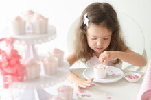 カップケーキにトッピングをするハーフの女の子