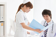 © amanaimages - カルテを見る医師と看護師