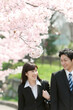 © amanaimages - 桜の下のビジネスマンとビジネスウーマン