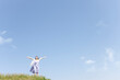 © amanaimages - 空を見上げて腕を広げる女性