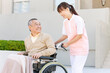 © amanaimages - 女性介護士と車いすに乗った中高年男性