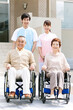 © amanaimages - 介護士と車いすに乗った中高年男女