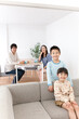 © amanaimages - リビングでくつろぐ4人家族